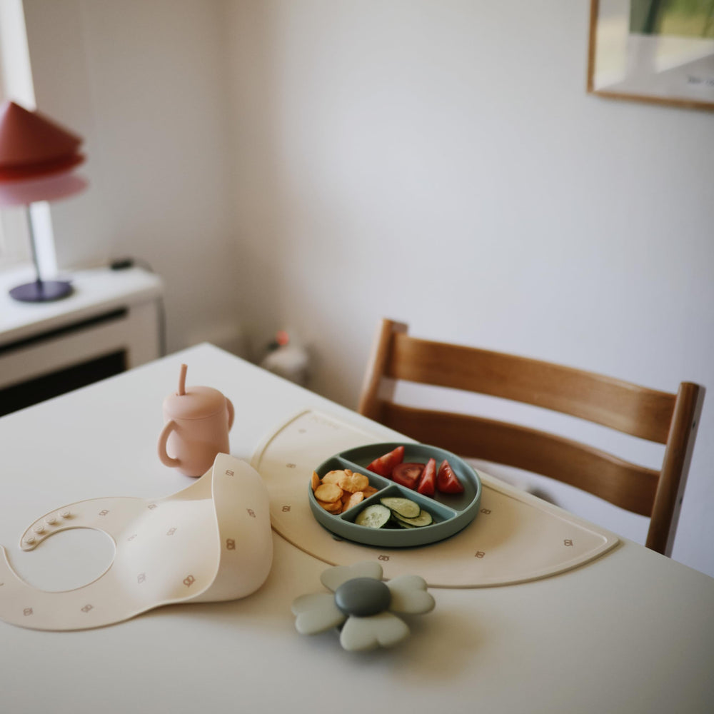 Mushie silicone baby bib Pretzel Swedish design complements placemats and tableware.