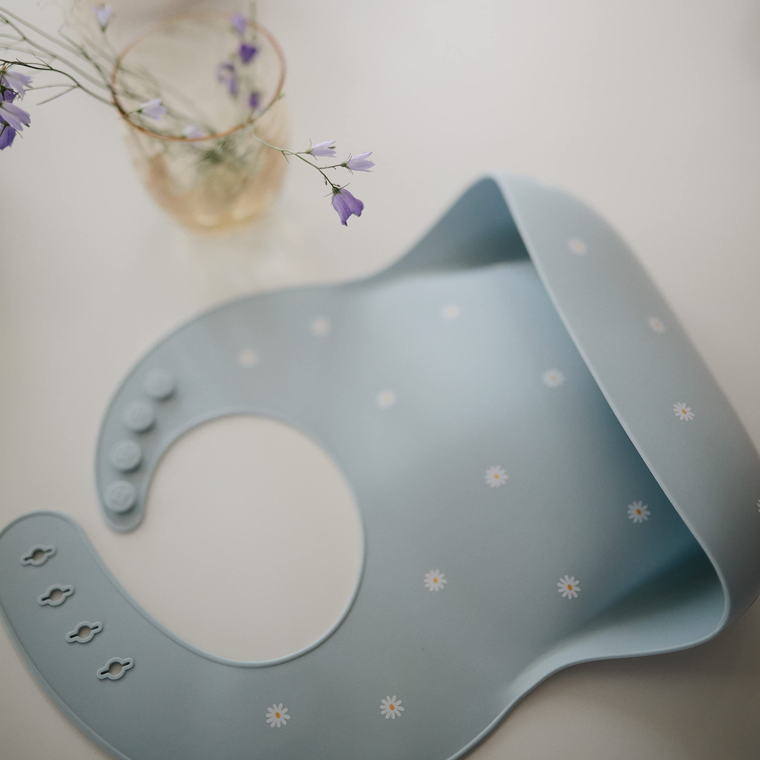 Mushie bib cleaning scene showing stain resistant surface