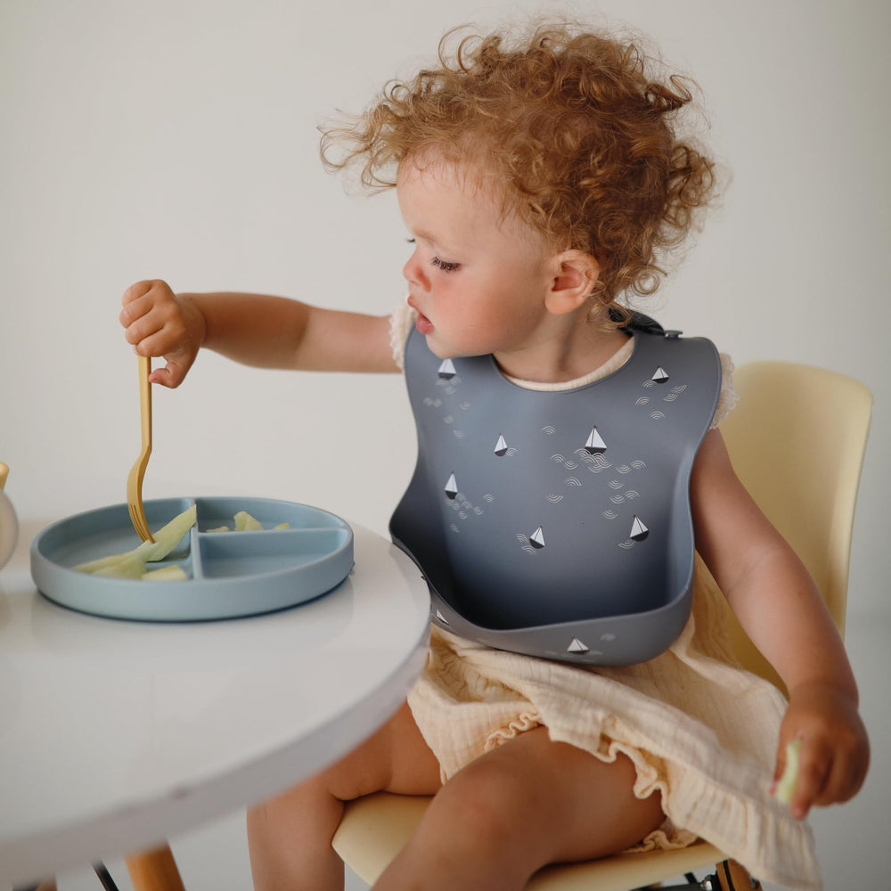 Mushie Tradewinds pattern coordinates with placemats and tableware for stylish dining.