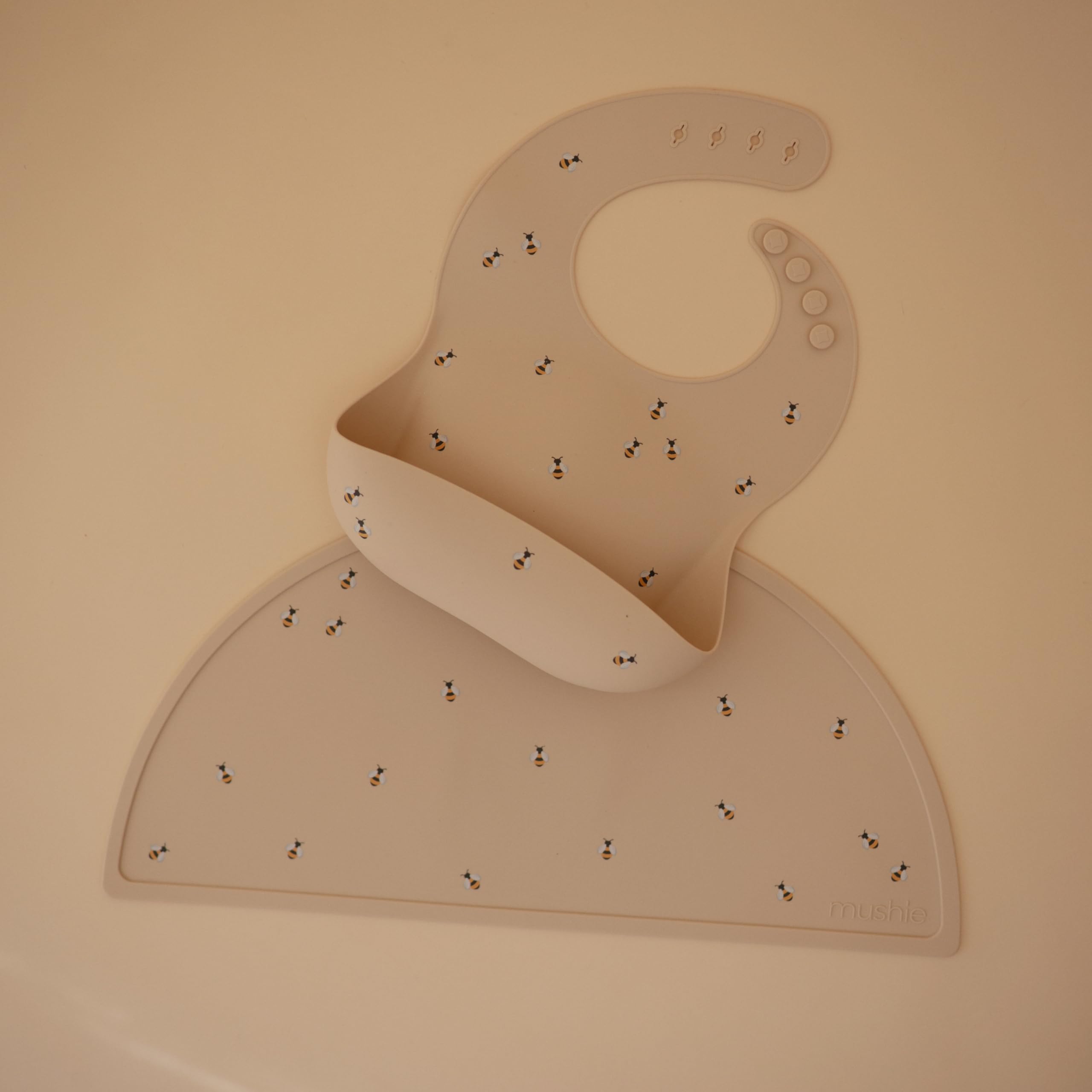 Mushie silicone bib in waterproof bees design catches spills during feeding