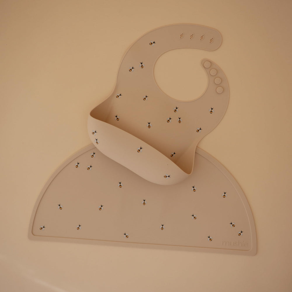 Mushie silicone bib in waterproof bees design catches spills during feeding