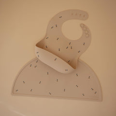 Mushie silicone bib in waterproof bees design catches spills during feeding