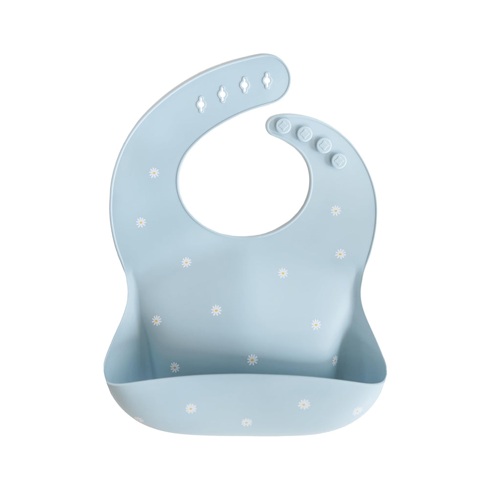 Mushie silicone baby bib White Daisy closeup highlighting waterproof mess protection
