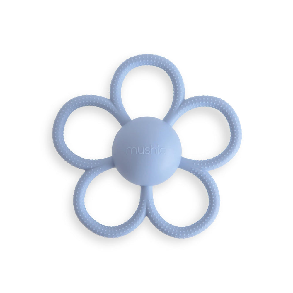 Mushie Daisy Rattle Teether in faded denim with textured silicone for gum massage and self-soothing.