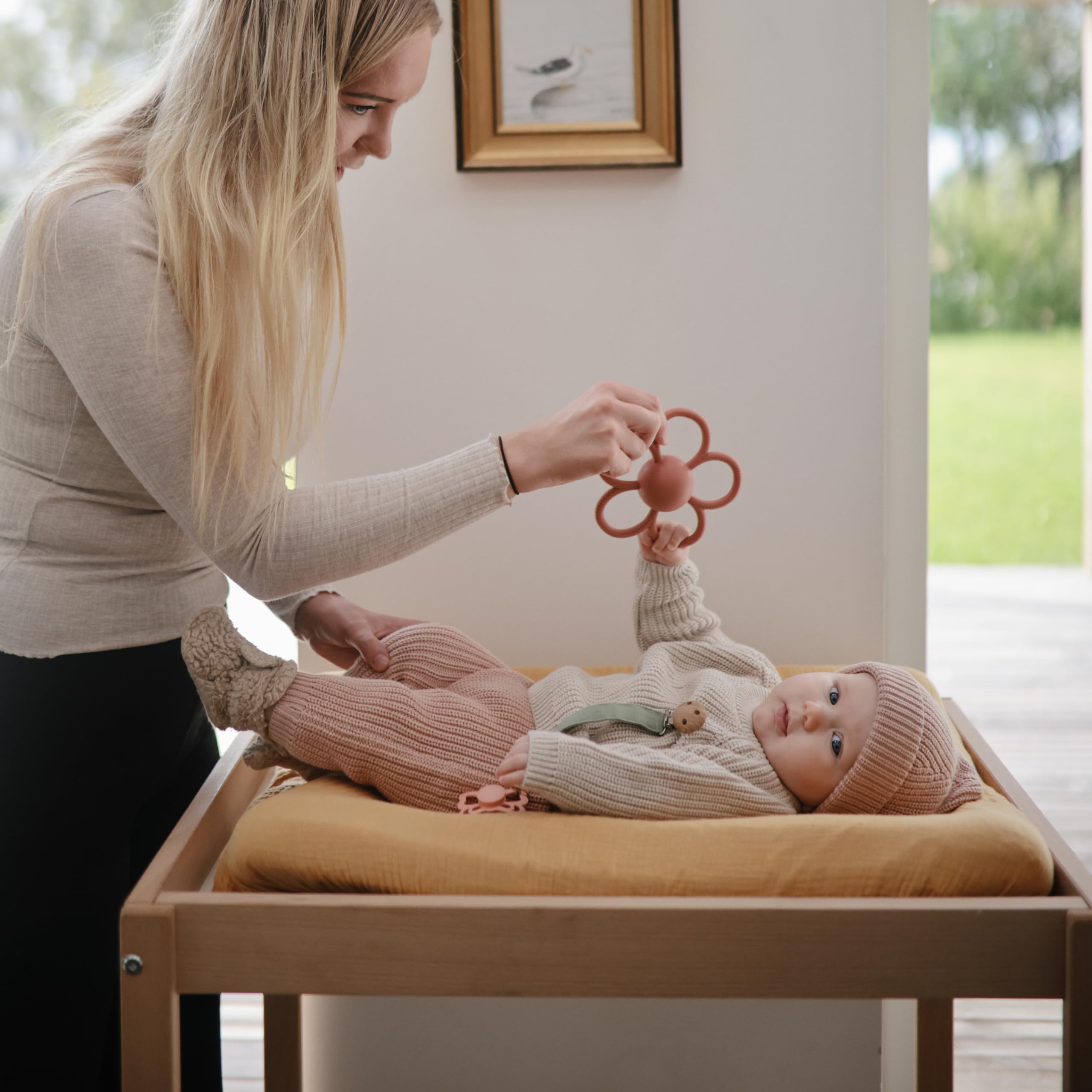 Mushie rattle teether with easy-to-grasp handle for tiny hands.