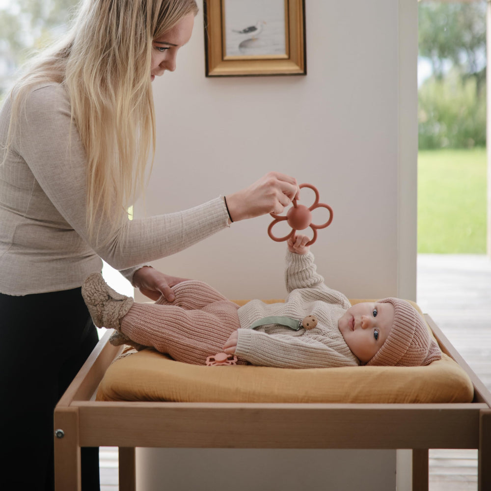 Mushie rattle teether with easy-to-grasp handle for tiny hands.