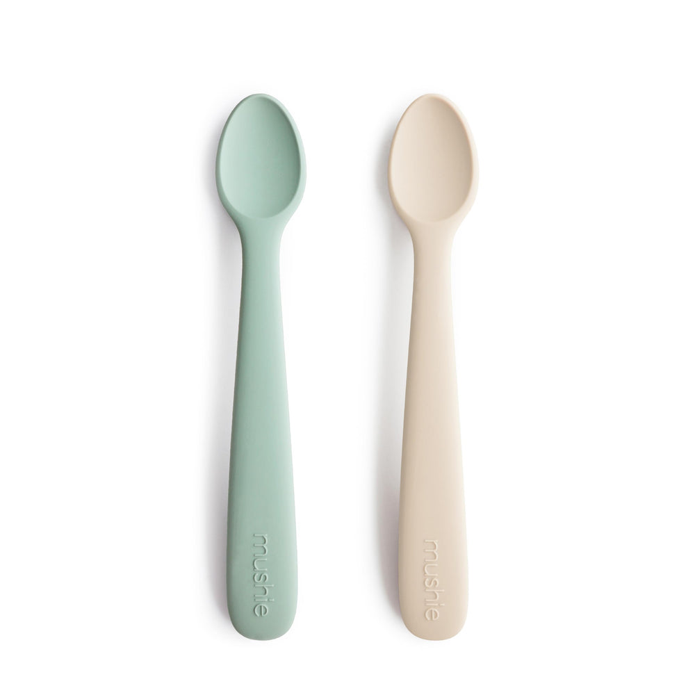 Mushie silicone baby feeding spoons 2-pack Cambridge Blue Shifting Sand pack shot promotes easy mealtime.