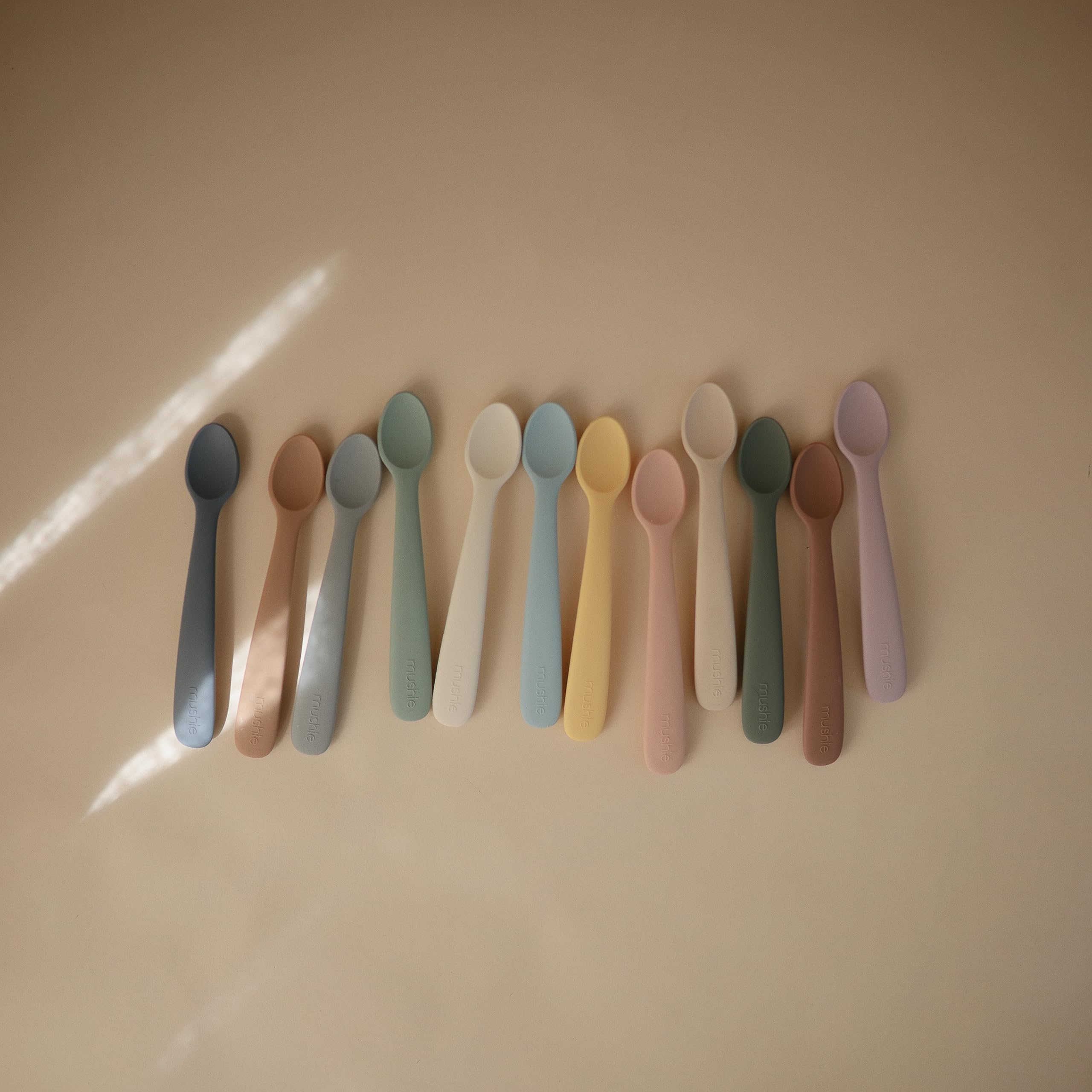 Mushie spoons in use at mealtime with caregiver