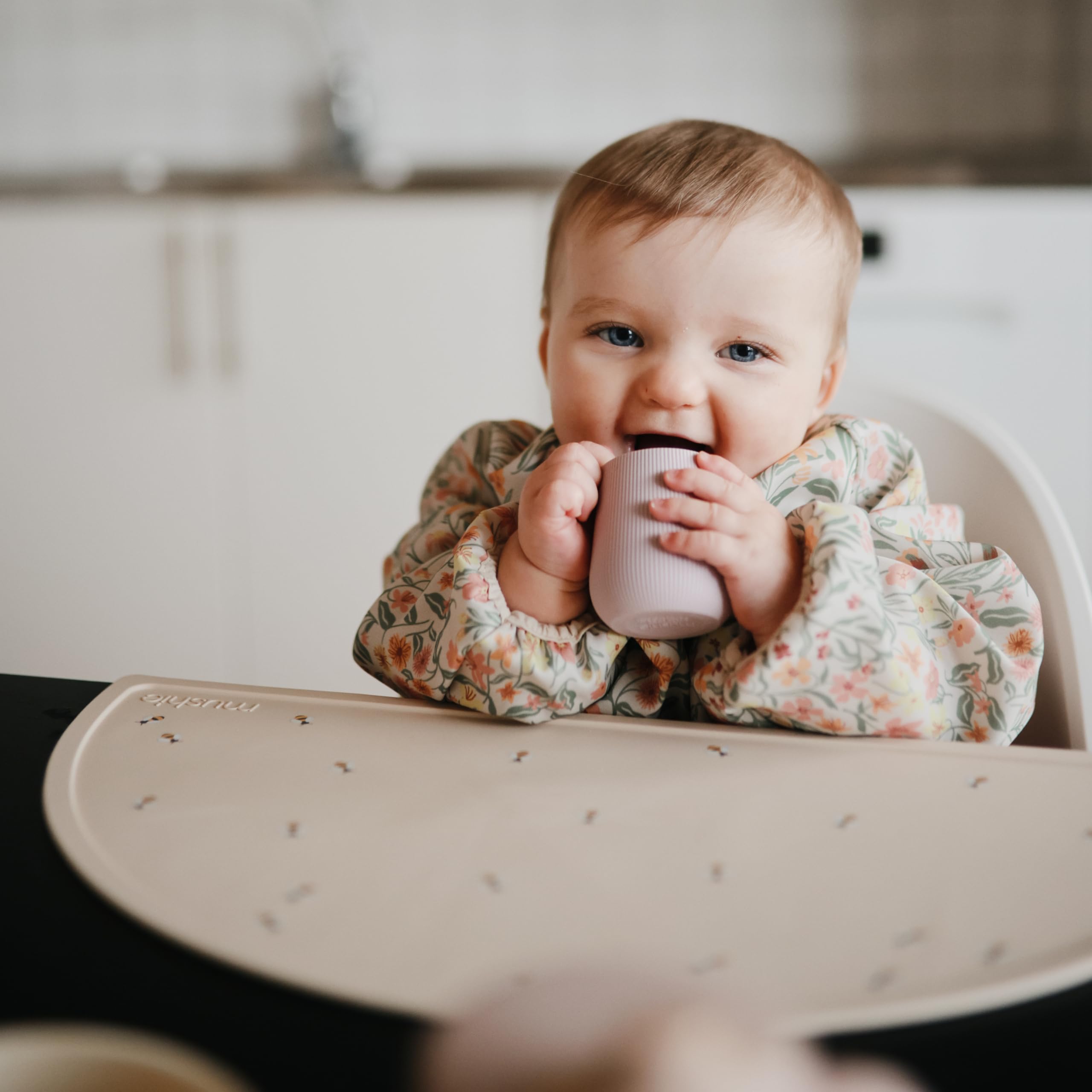 Mushie starter cup's weighted base reduces tipping for easier self-feeding sessions.