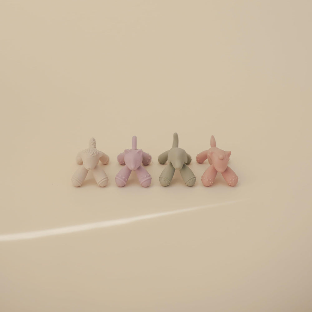 Mushie silicone teether held by tiny hands for on-the-go soothing