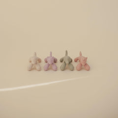 Mushie silicone teether held by tiny hands for on-the-go soothing