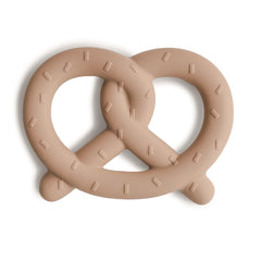 Mushie silicone baby teether pretzel closeup showing soft bite surface for teething relief.