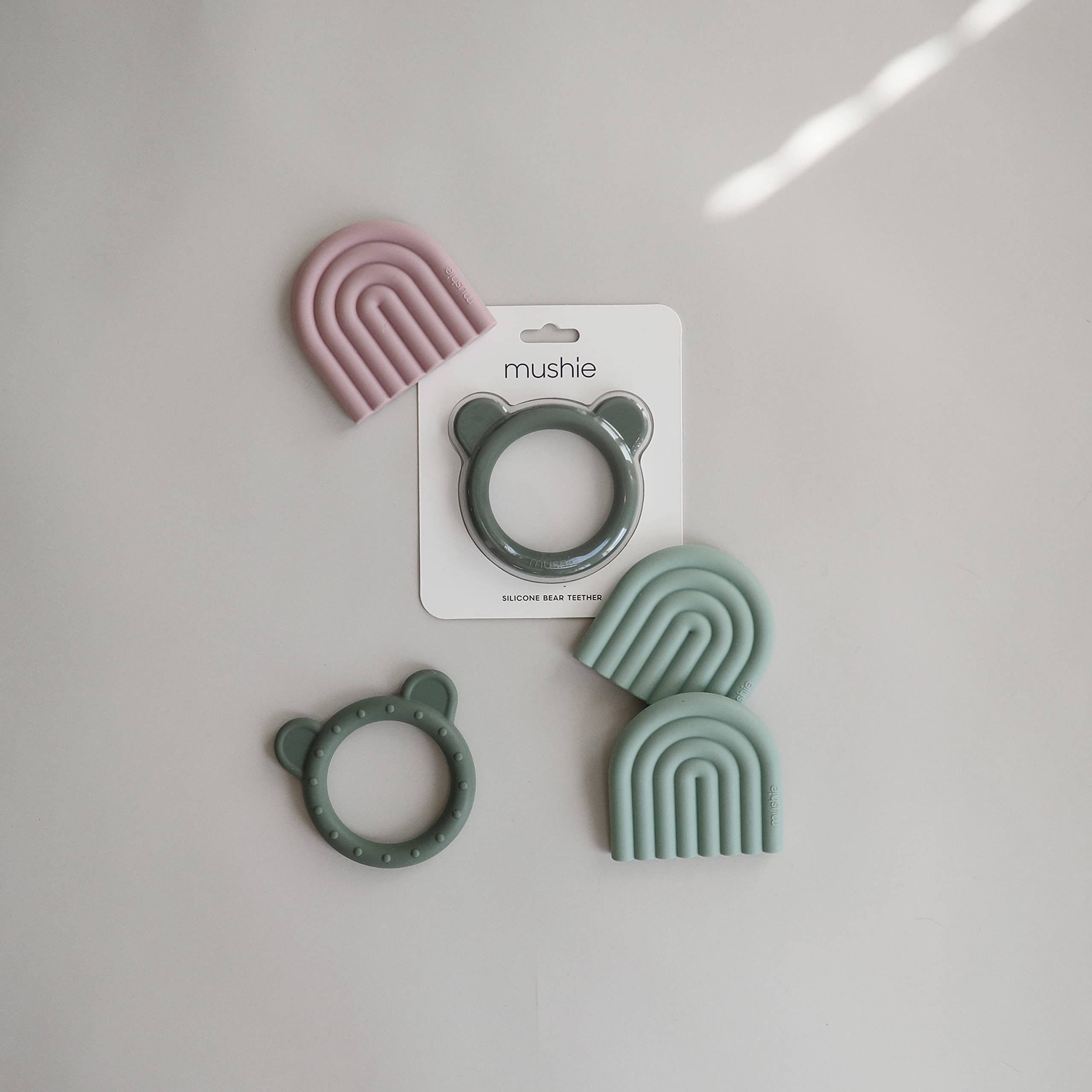Mushie teether Rainbow Cambridge Blue in hand for comfy grip and safe chewing