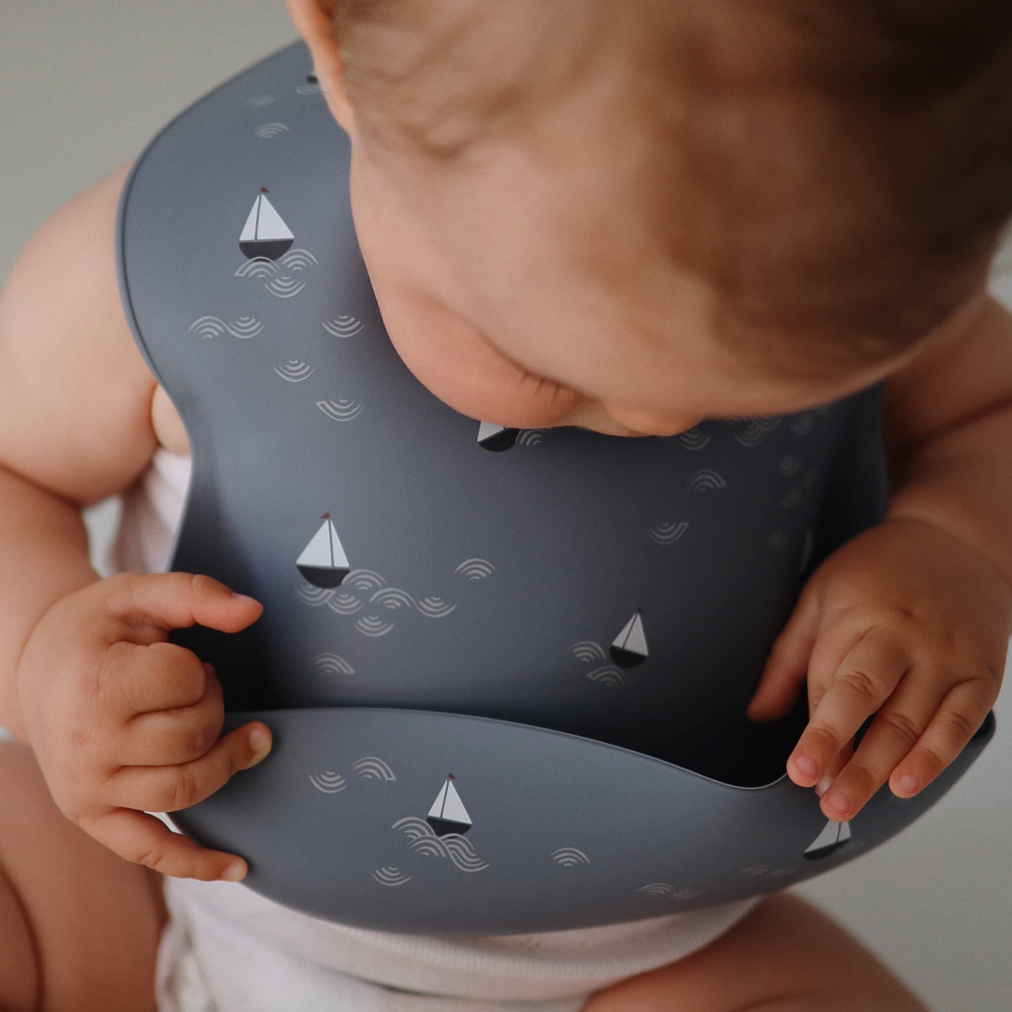 Mushie silicone bib adjustable neck ensures snug, comfortable fit for growing toddlers.