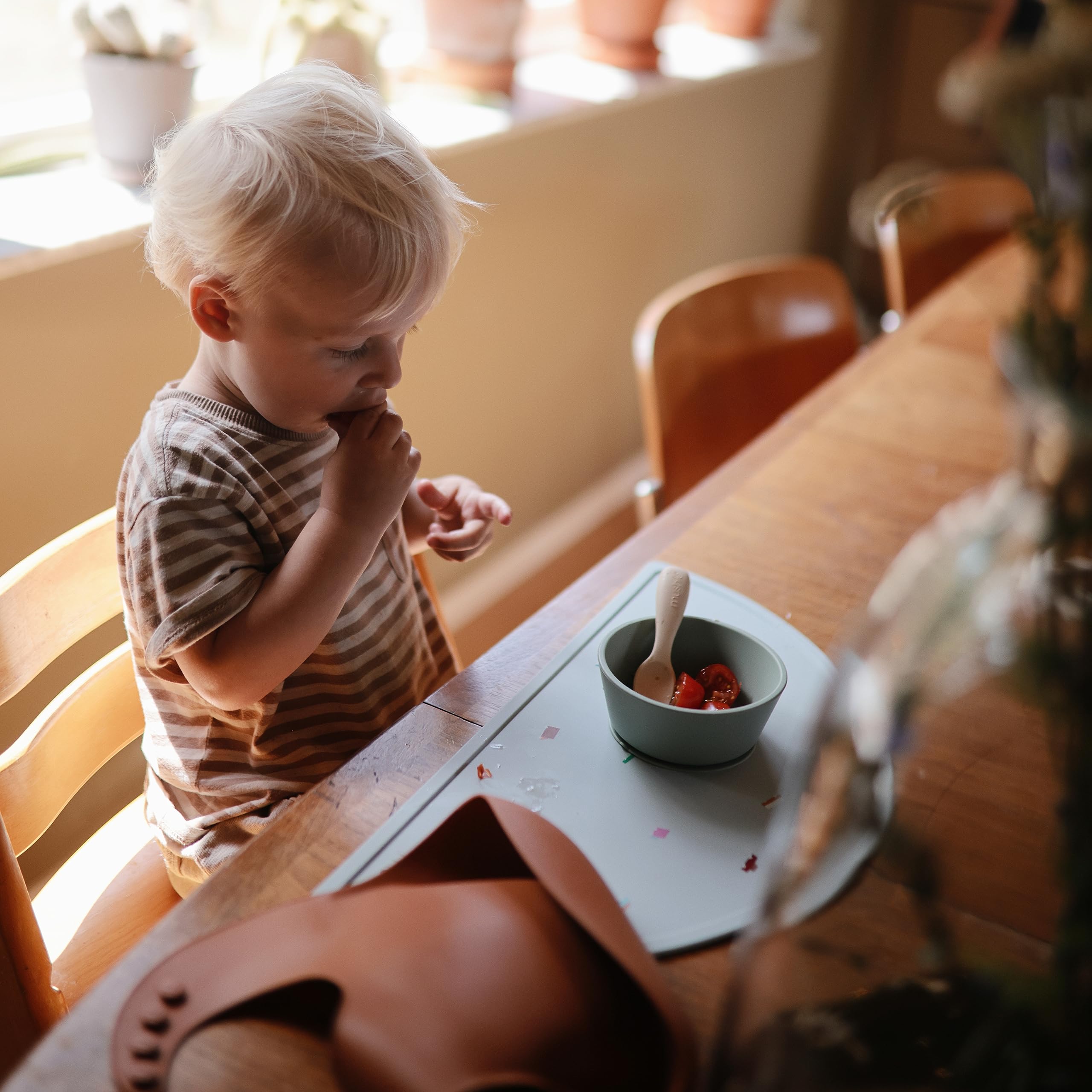 Mushie silicone bib clay adjustable neck-strap worn during feeding for snug fit