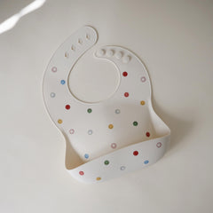 Mushie silicone bib deep pocket catching crumbs and spills