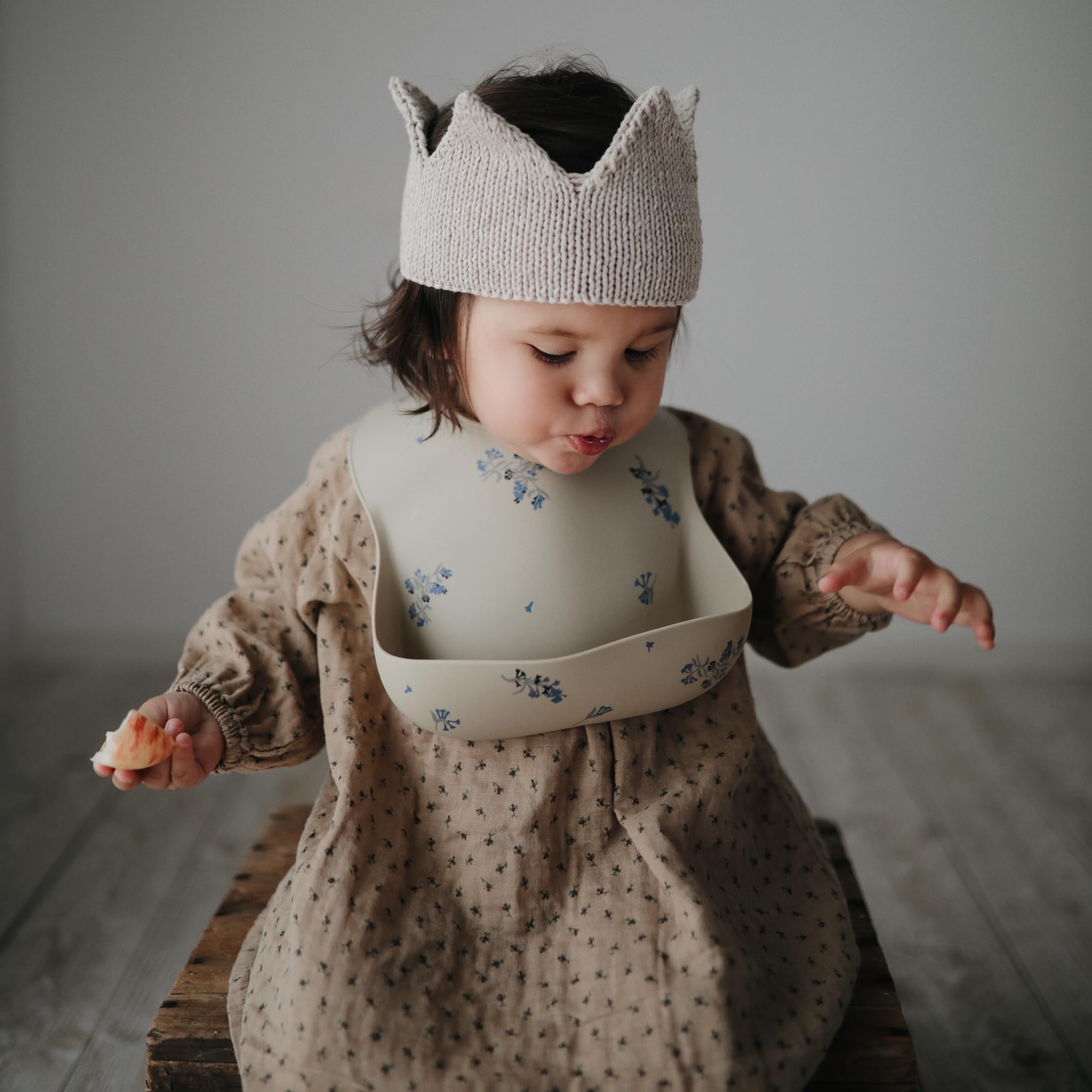Mushie Lilac Flowers bib demonstrates adjustable-fit concept for growing babies.