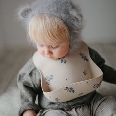 Mushie Lilac Flowers bib deep pocket ready to catch crumbs during meals.