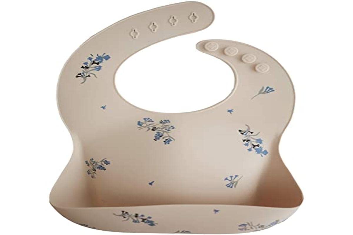 Mushie Lilac Flowers bib on table highlighting stain-resistant surface for quick wipe-down.