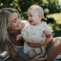Mushie silicone bib deep pocket catches spills to keep surfaces cleaner