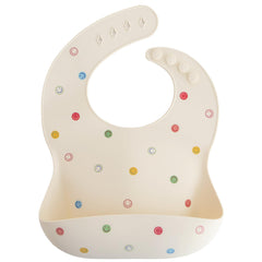 Mushie silicone bib smiley face closeup highlights stain-resistant material