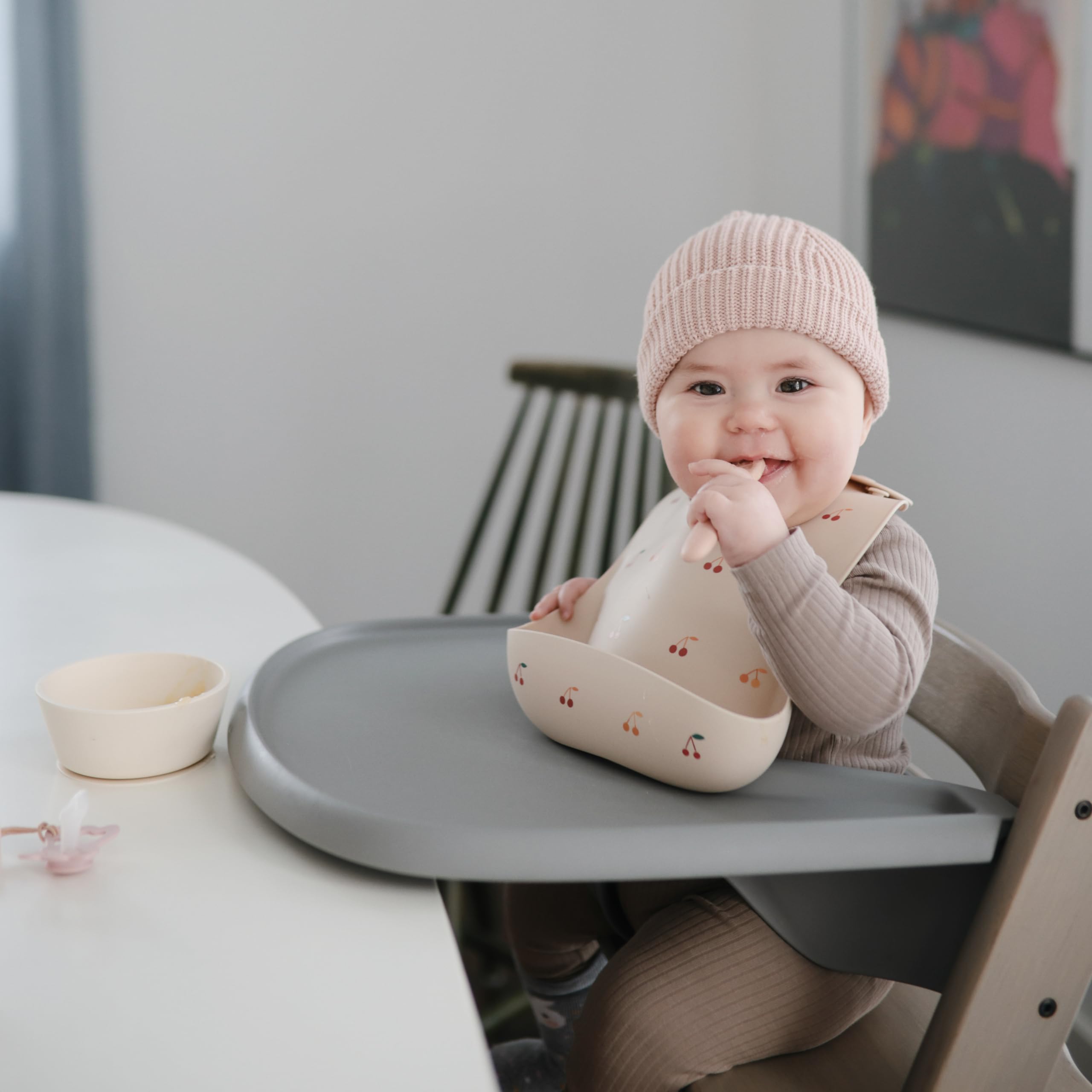 Mushie bib waterproof cherries keeps clothes clean between wipes.