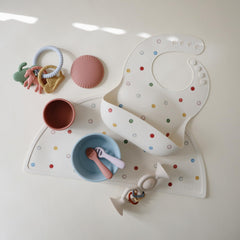 Mushie silicone bib stays waterproof and wipes clean for quick messes