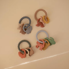Mushie silicone dino teething ring back view highlighting three dinosaur shapes
