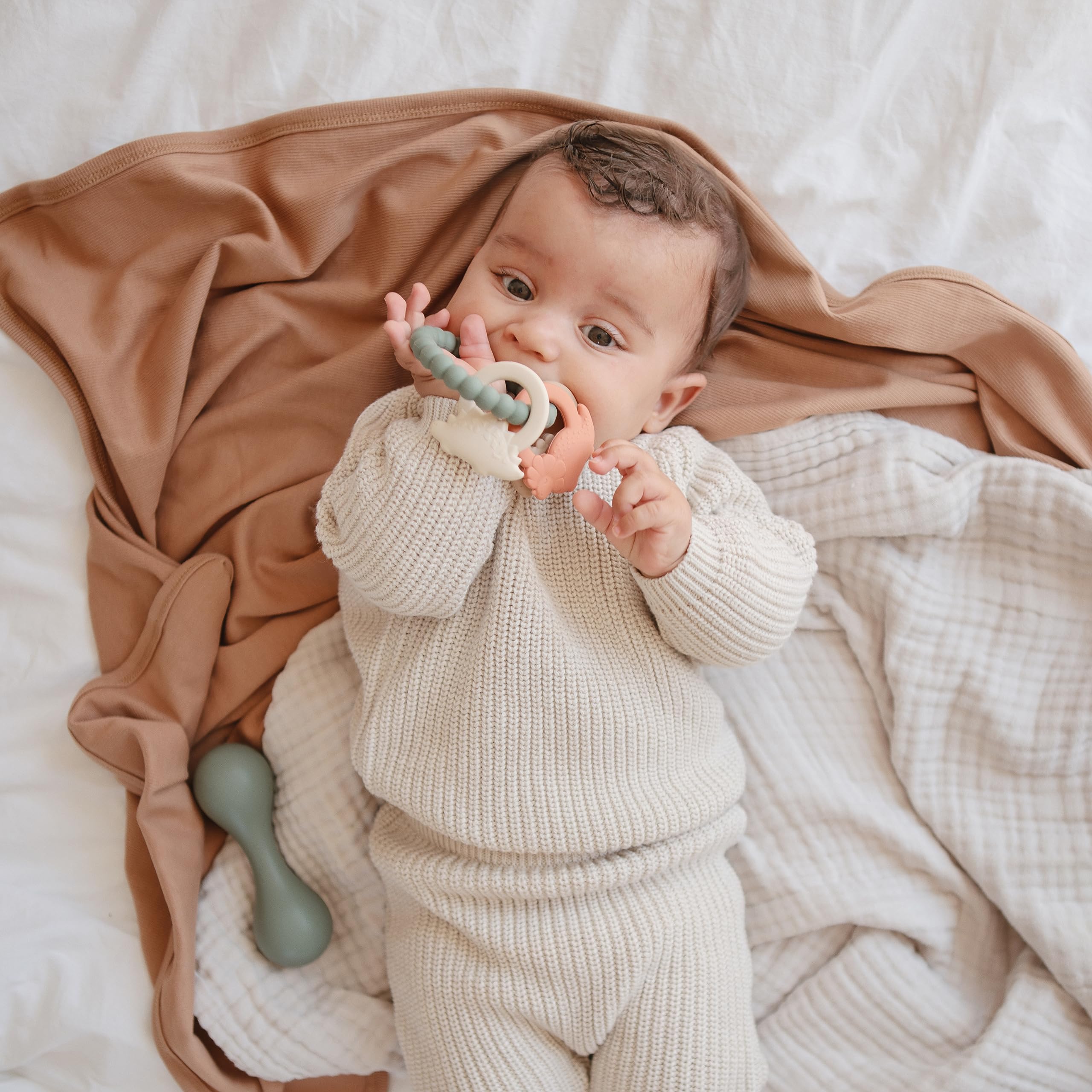 Mushie silicone dino teething ring texture closeup reveals soft silicone surfaces