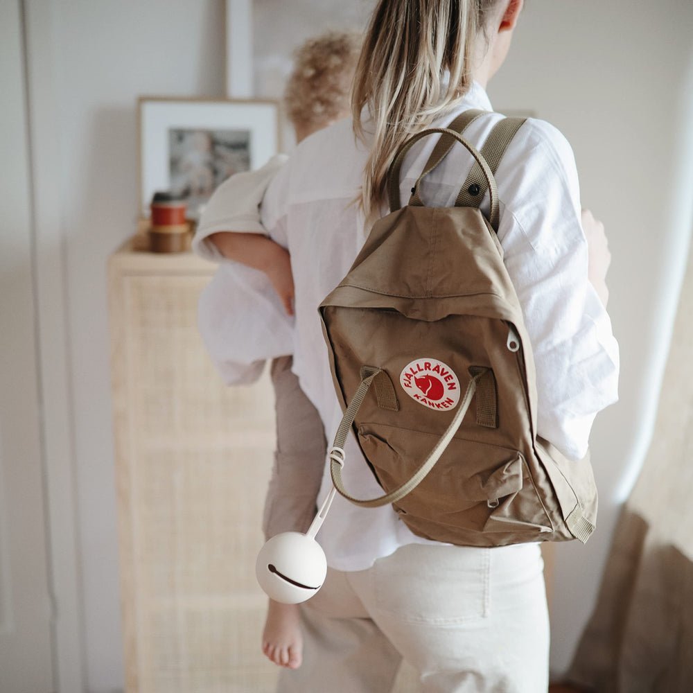 Mushie Shifting Sand case stored in a diaper bag with two pacifiers