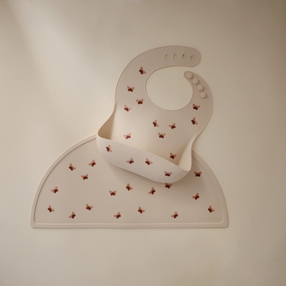 Mushie placemat butterflies on a tray shows easy-to-clean silicone in action.