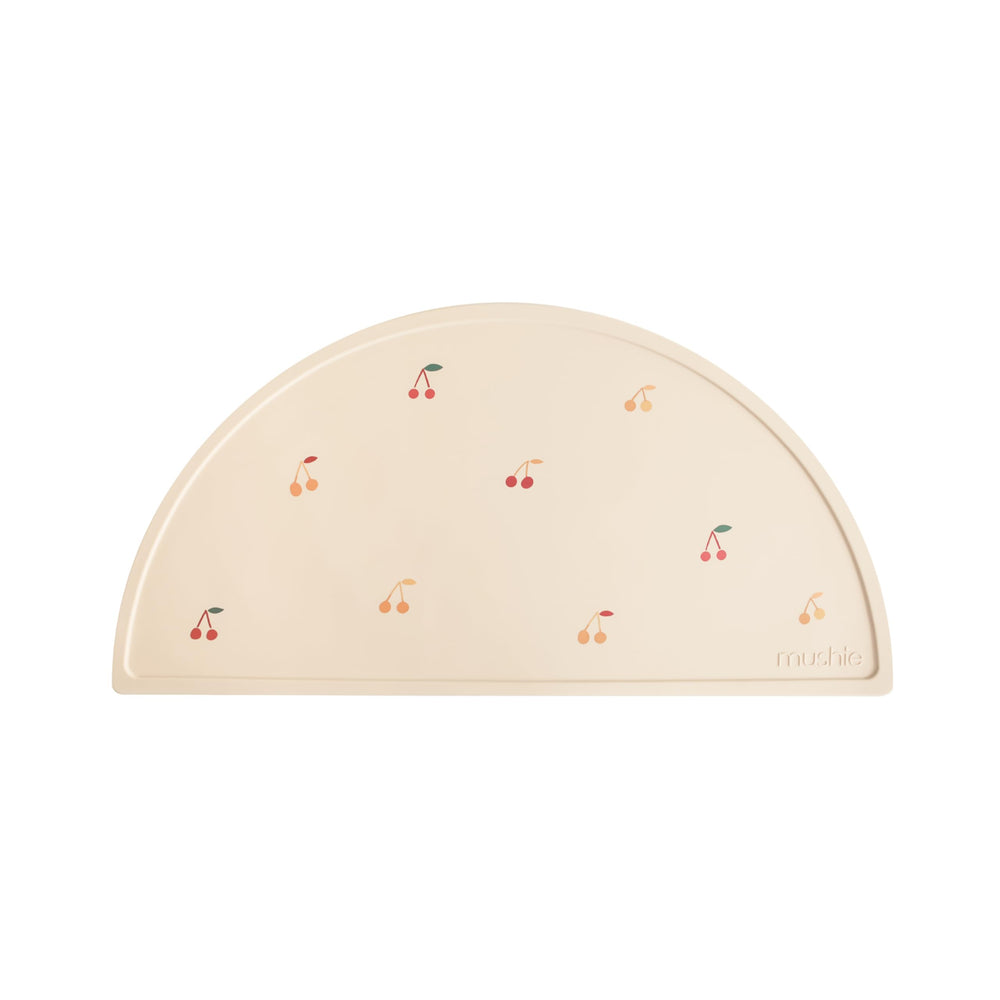 Mushie silicone placemat cherries hero shot highlighting non-slip surface for stable mealtime.
