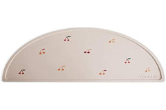 Mushie cherries placemat on colorful table emphasizing easy to clean silicone material.