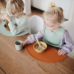 Mushie silicone placemat clay easy-clean material resists stains and wipes clean after use.