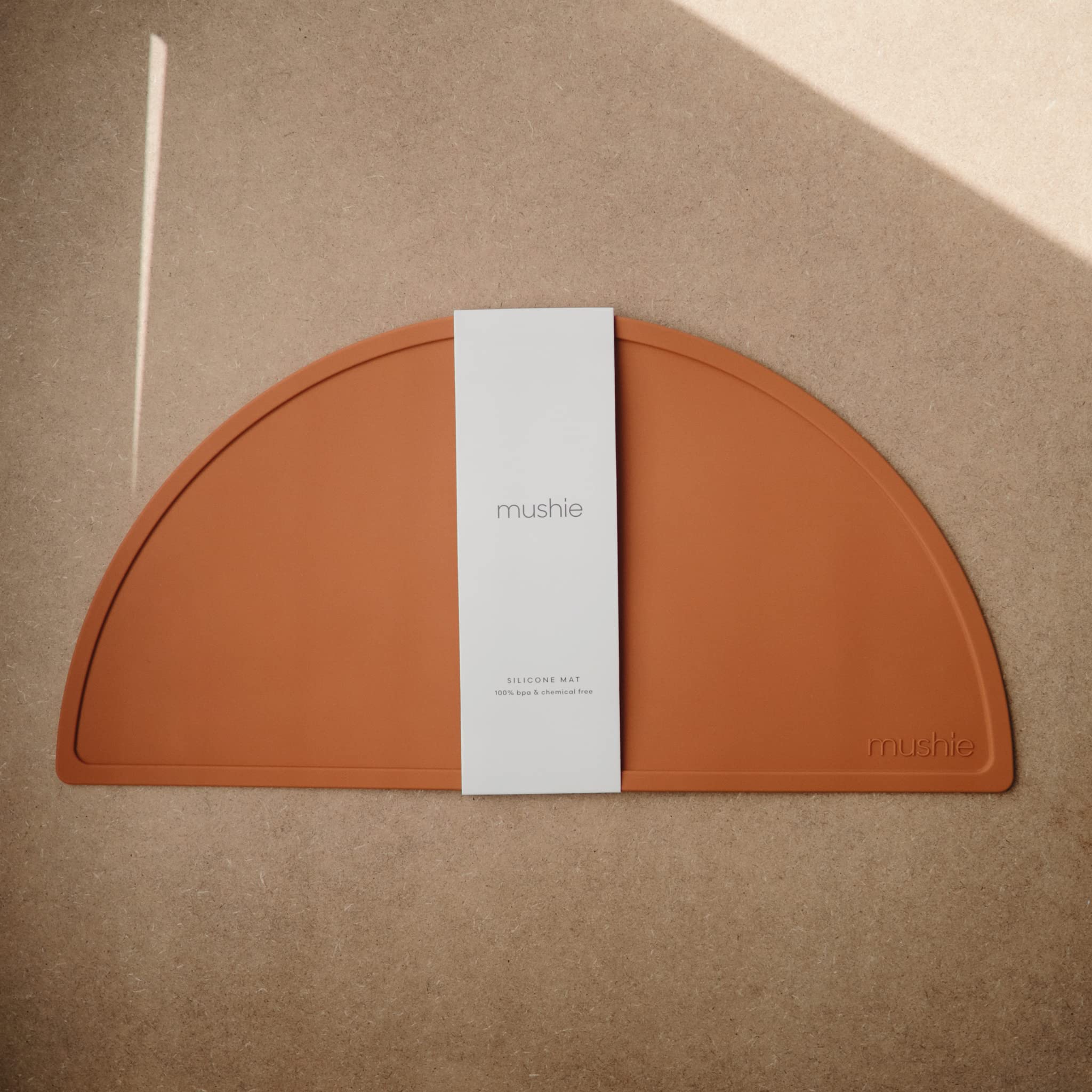 Mushie silicone placemat clay non-slip bottom keeps plates in place during meals.