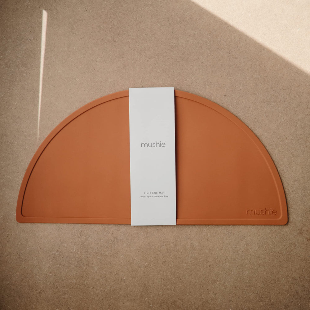 Mushie silicone placemat clay non-slip bottom keeps plates in place during meals.