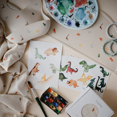 Mushie silicone placemat dinosaurs; stain-resistant surface cleans easily after snacks.