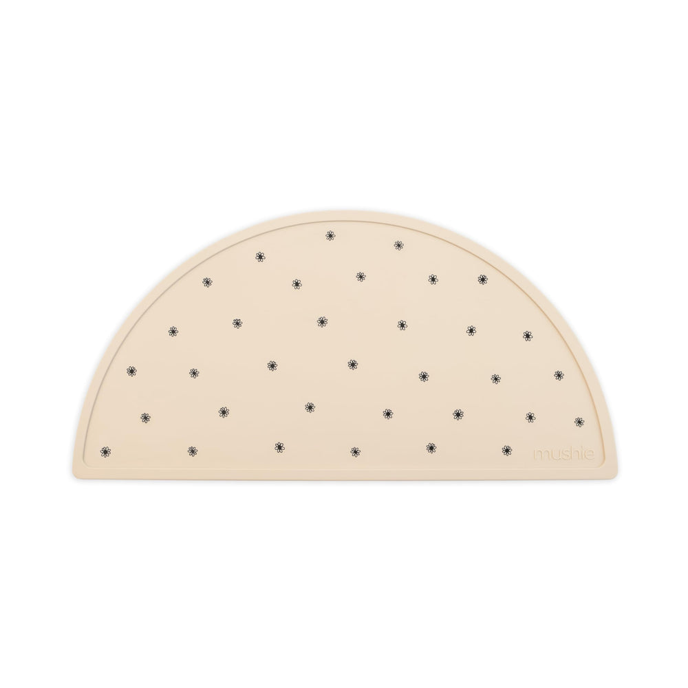 Mushie silicone placemat in Black Daisy keeps meals tidy and stylish at home.