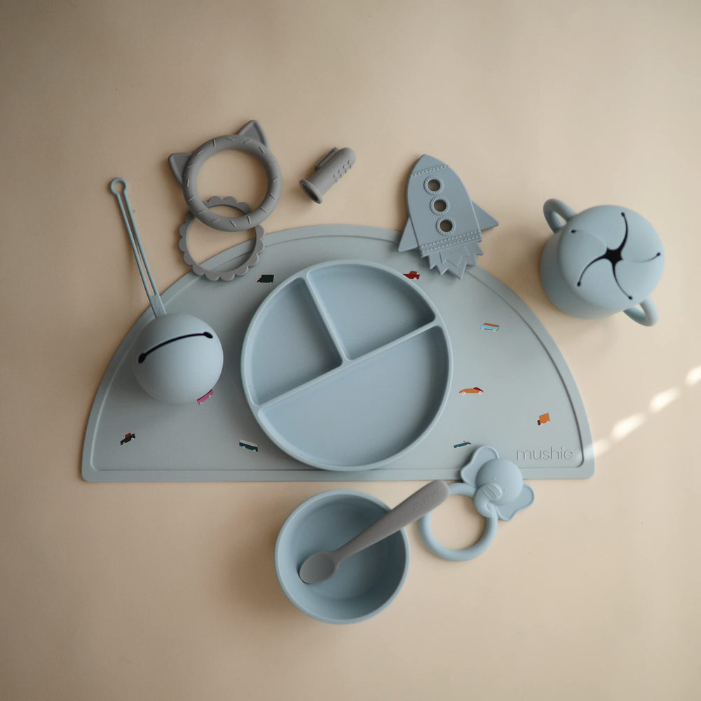 Mushie silicone placemat coordinates with dinnerware for a cohesive mealtime look