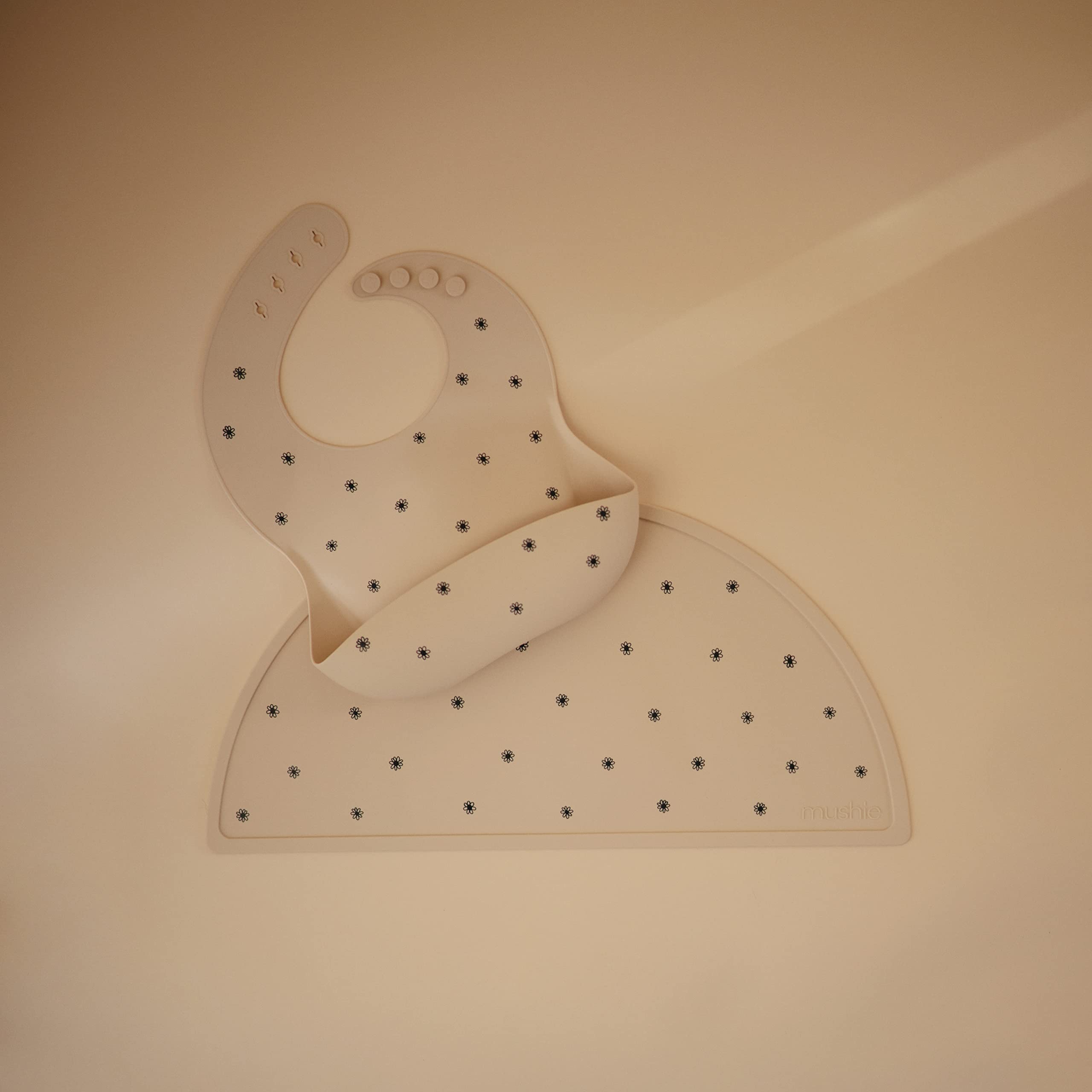 Mushie placemat pattern closeup shows stain-resistant surface for easy cleaning.