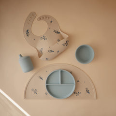 Mushie silicone placemat Lilac Flowers dishwasher-safe badge for quick cleaning.