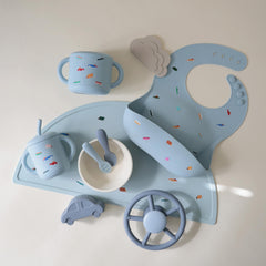 Mushie silicone snack cup soft opening for tiny hands during self-feeding.