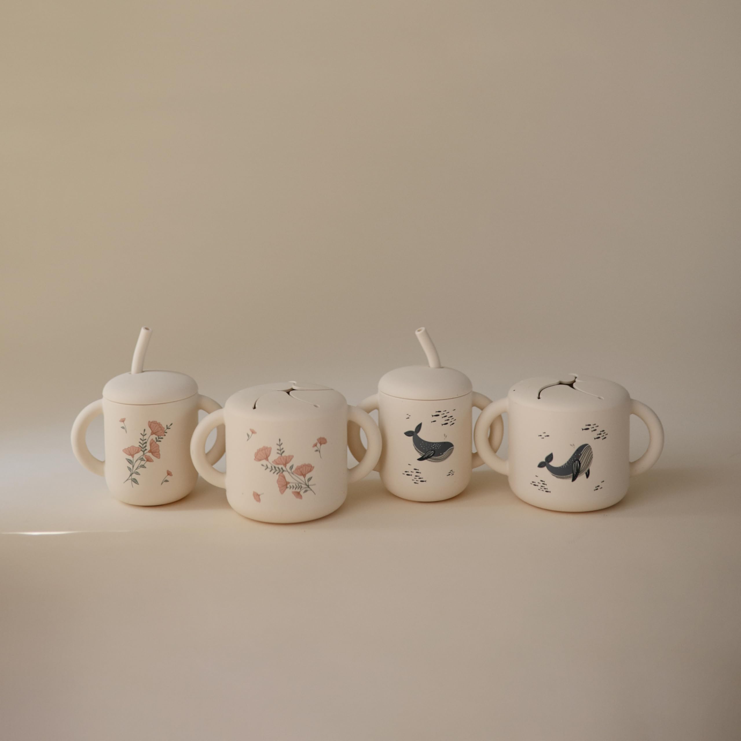 Mushie silicone snack cup whales in use on the go with snacks easily accessible.