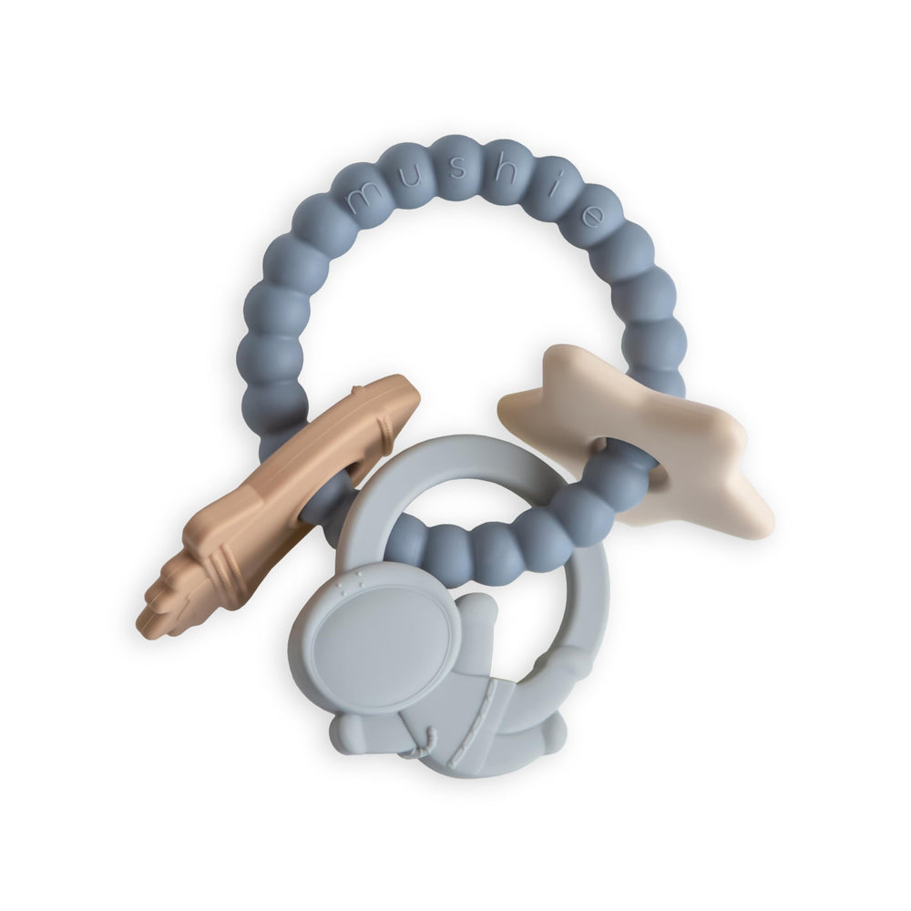 Mushie silicone space teething ring closeup texture moon and stars soothes gums.