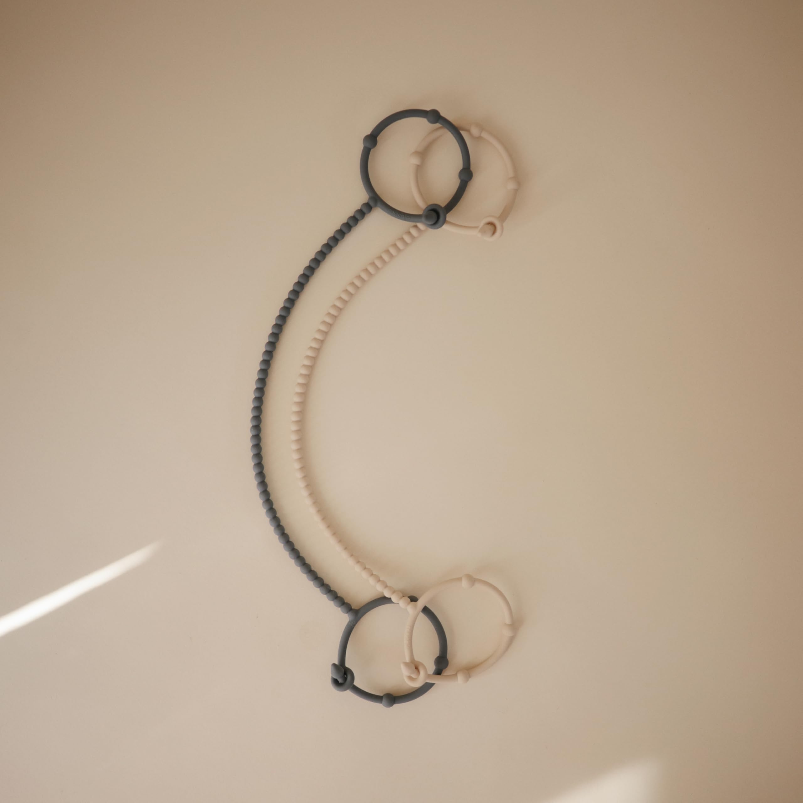 Mushie silicone straps hold a pacifier for easy access and reduced drops.