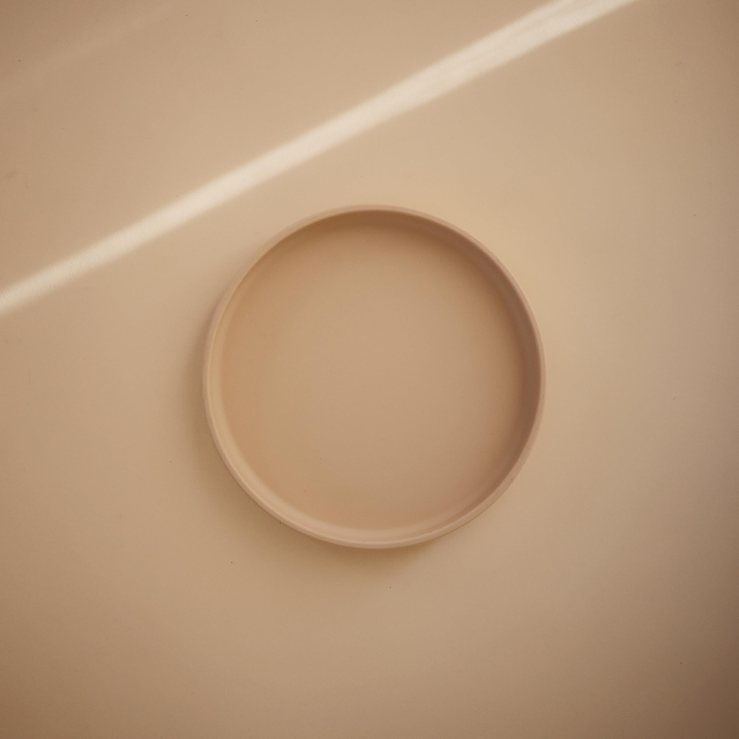 Mushie suction plate on a dry surface demonstrating spill-free mealtime use