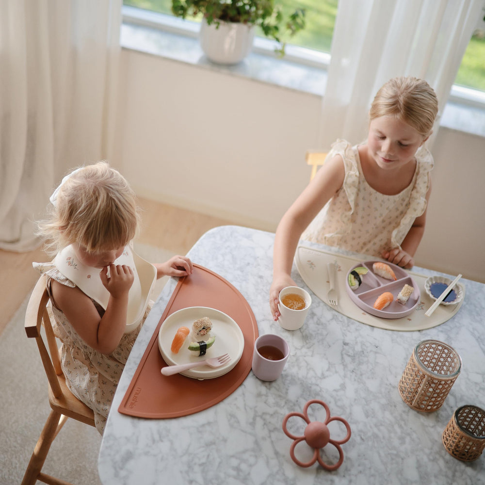 Mushie silicone suction plate ivory food-safe material enables direct heating of small portions.