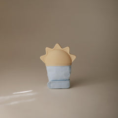 Mushie teething mitten worn on hand for hands-free soothing during teething