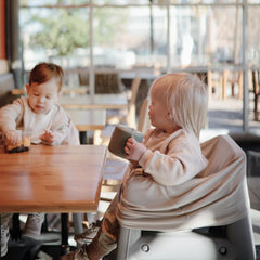 Mushie snack cup held by a child during car travel