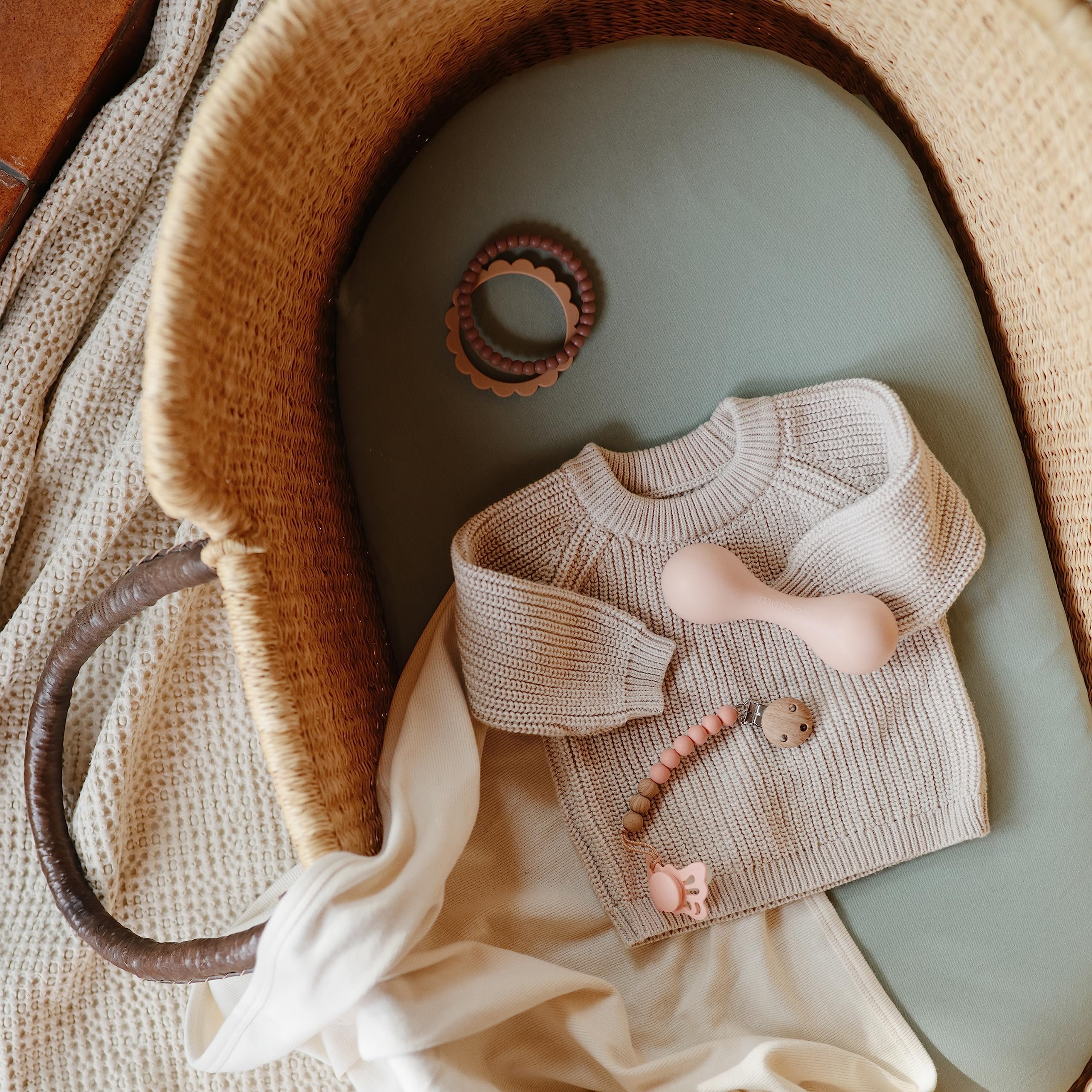 Mushie Roman Green sheet with folded presentation on bassinet